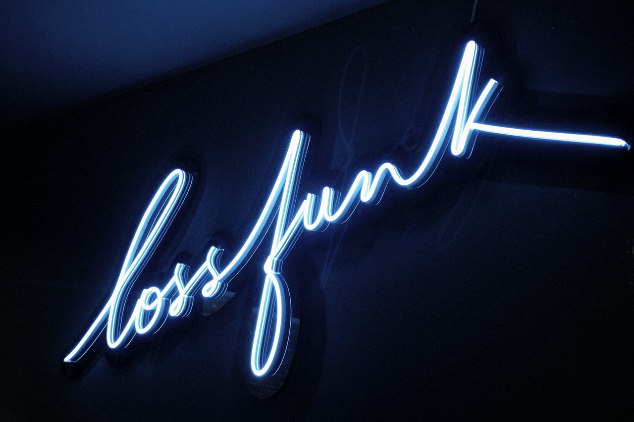 the lossfunk neon sign on the wall of the venue